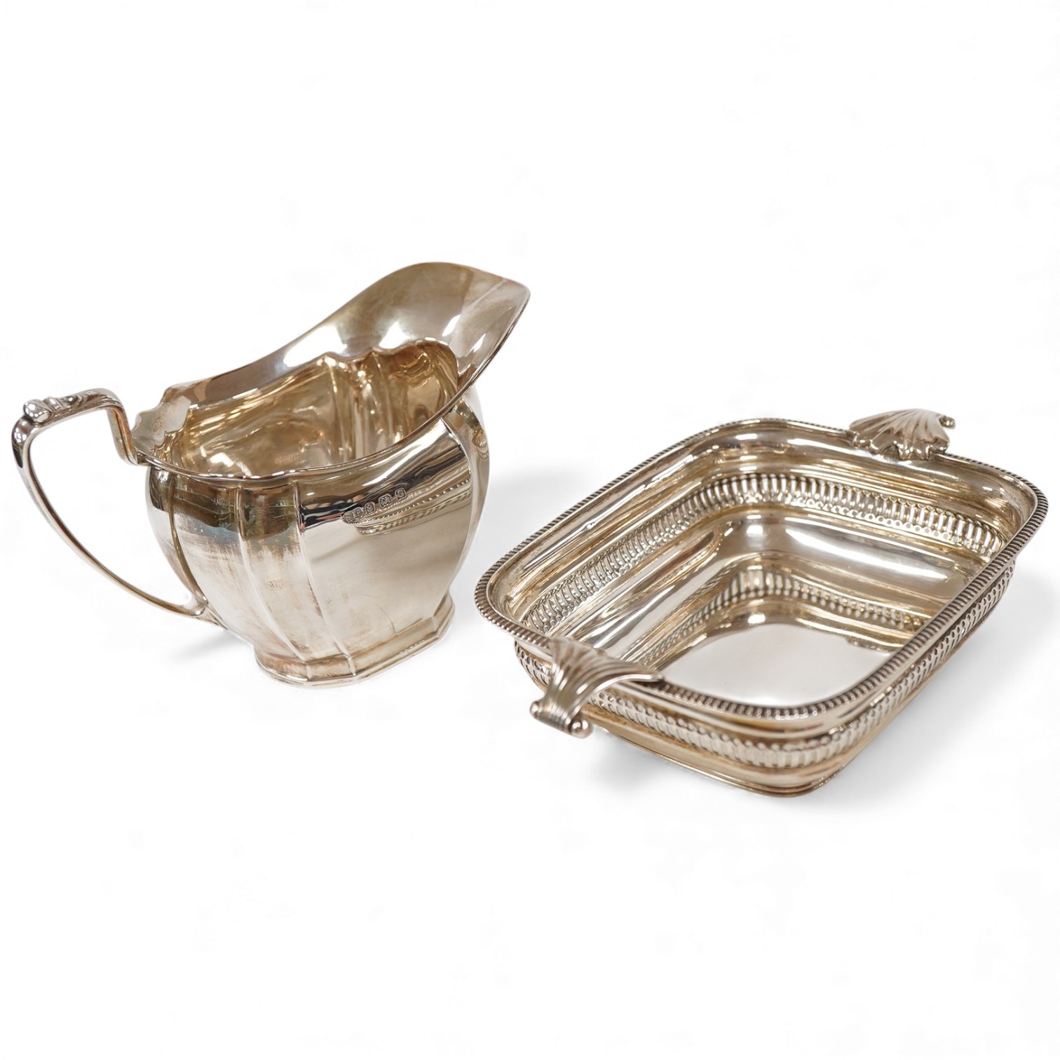 A George V silver two handled butter dish, by George Howson, Sheffield, 1928, 16.7cm over handles, together with a George V silver cream jug, by William Suckling Ltd, Birmingham, 1931, 10.7oz.